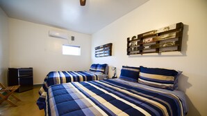 A bedroom with two beds, a small desk, and a wall-mounted shelf with books. - Carmen's Marfa Hotel/Leticia 2 Queen Beds (Marfa)