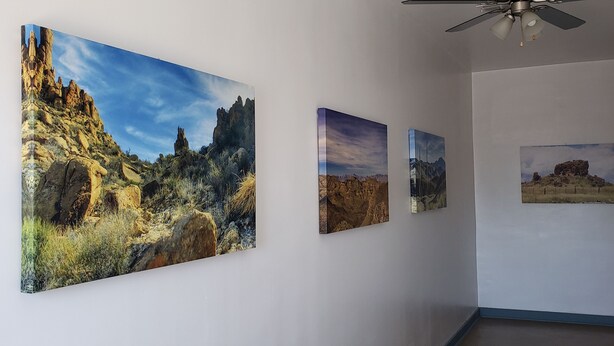 A hallway with three framed landscape paintings on the wall. - Carmen's Marfa Hotel/Leticia 2 Queen Beds (Marfa)