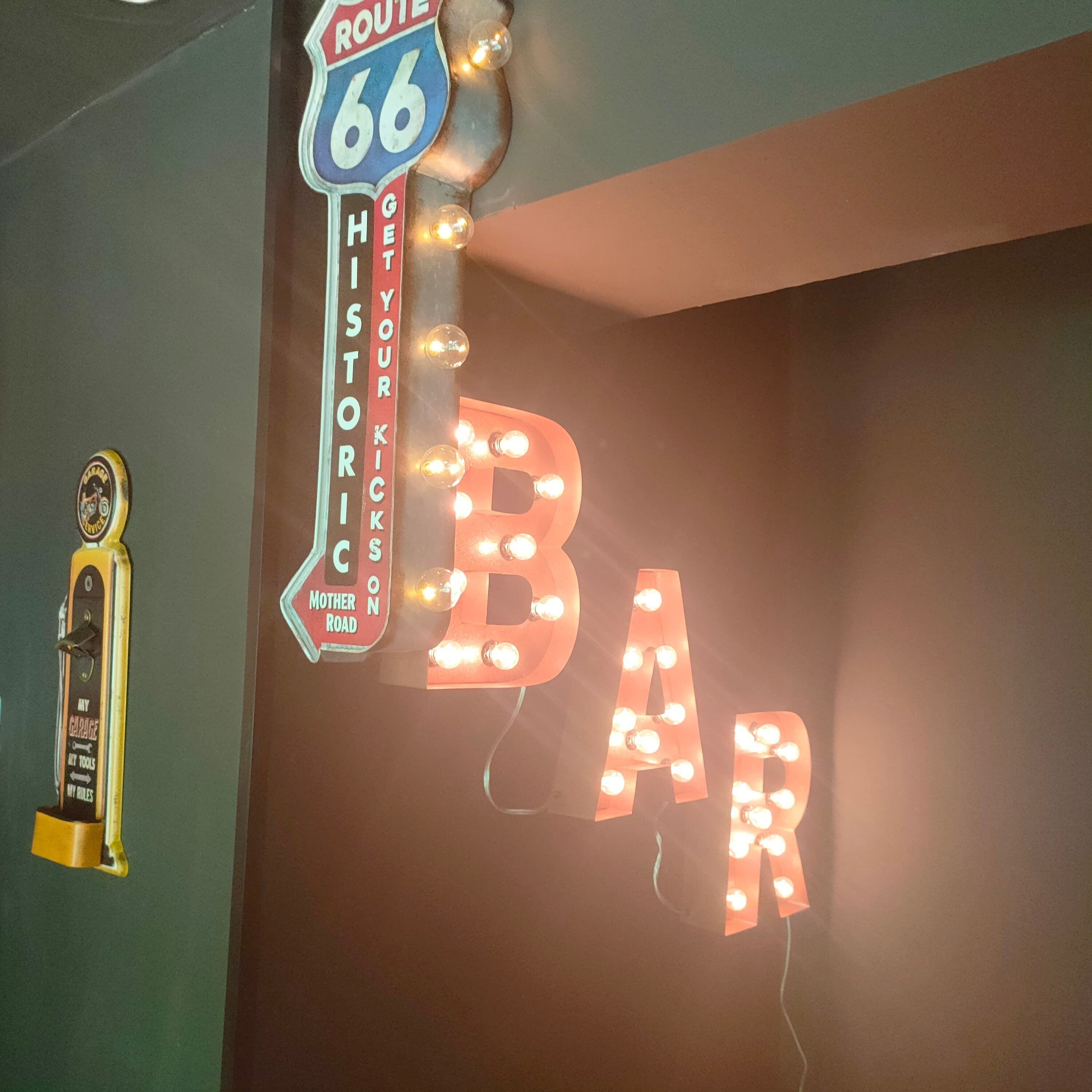 A neon sign with 'BAR' and 'ROUTE 66' on a wall.