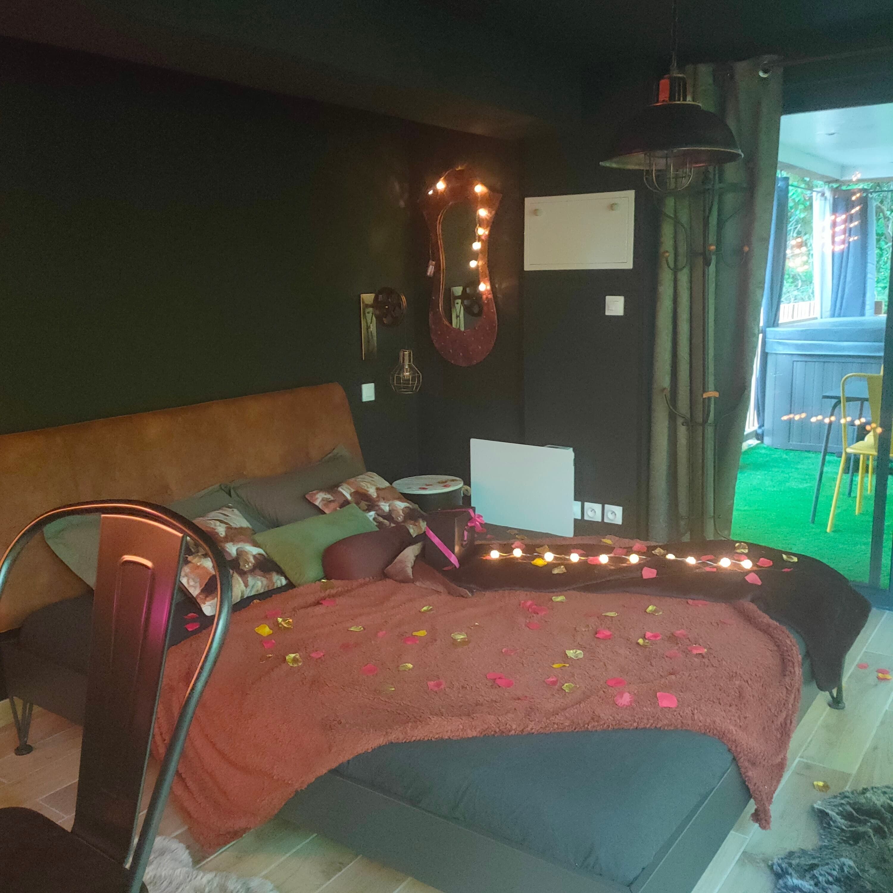 A bedroom with a bed, a desk, and a chair. There is a window with curtains and a view of the outside.