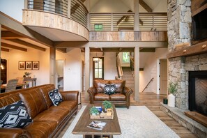 Relax in this inviting space with a leather sofa, stone fireplace, and mezzanine level.