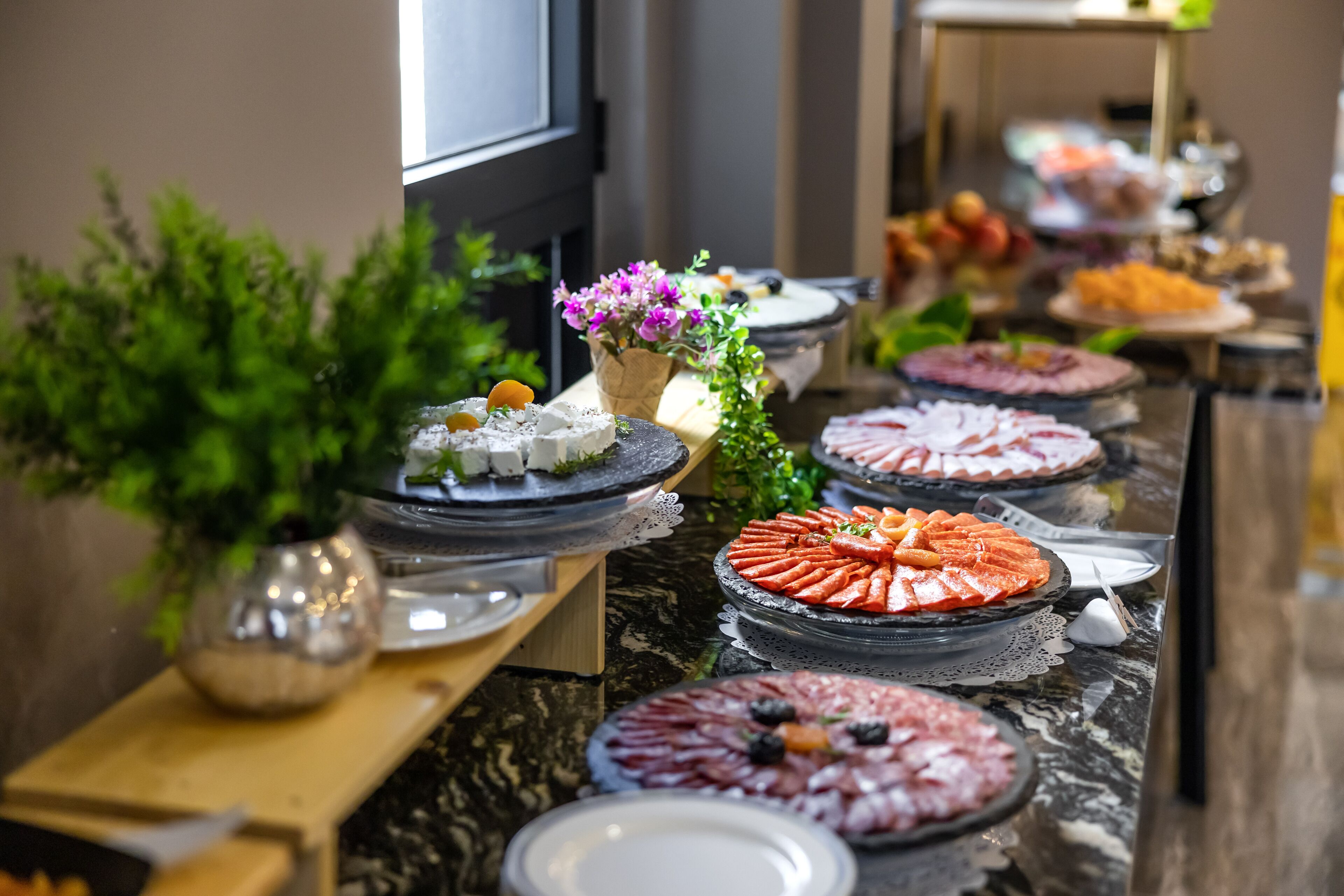 Ein reichhaltiges Buffet mit verschiedenen Speisen und einer Zimmerpflanze.