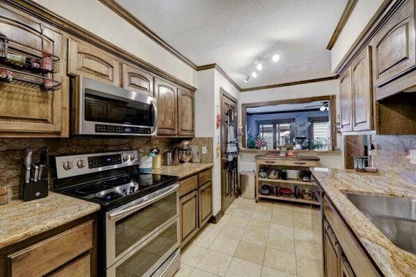 Enjoy cooking in this well-equipped kitchen with a microwave, oven, and stove, featuring a kitchen island with sink and storage.
