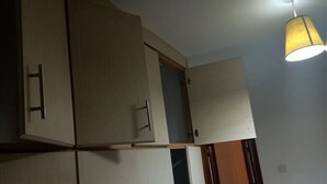 A room with wooden cabinets and a hanging lamp. - Cozy b n' b in Bunga (Kampala)