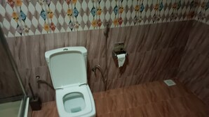 A bathroom with a toilet, a shower, and a hand dryer. - Cozy b n' b in Bunga (Kampala)