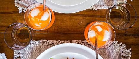 Two white plates of food with garnishes, placed on a wooden table with a white cloth underneath.