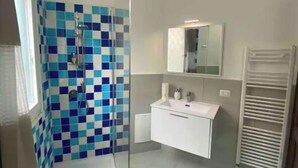 A bathroom with a shower, a sink, and a toilet. - Two-room apartment in Olbia (Olbia)