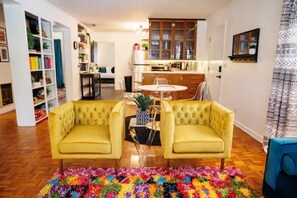A living room with a yellow sofa set, a coffee table, and a colorful rug. - CLOSE TO EVERYTHING! The Hidden Gem Dothan (Dothan)