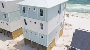 A beachfront hotel with multiple-story buildings, a sandy beach, and the ocean in the background. - Beachfront Luxury | Private Pool | Elevator | Pet Friendly (Gulf Shores)