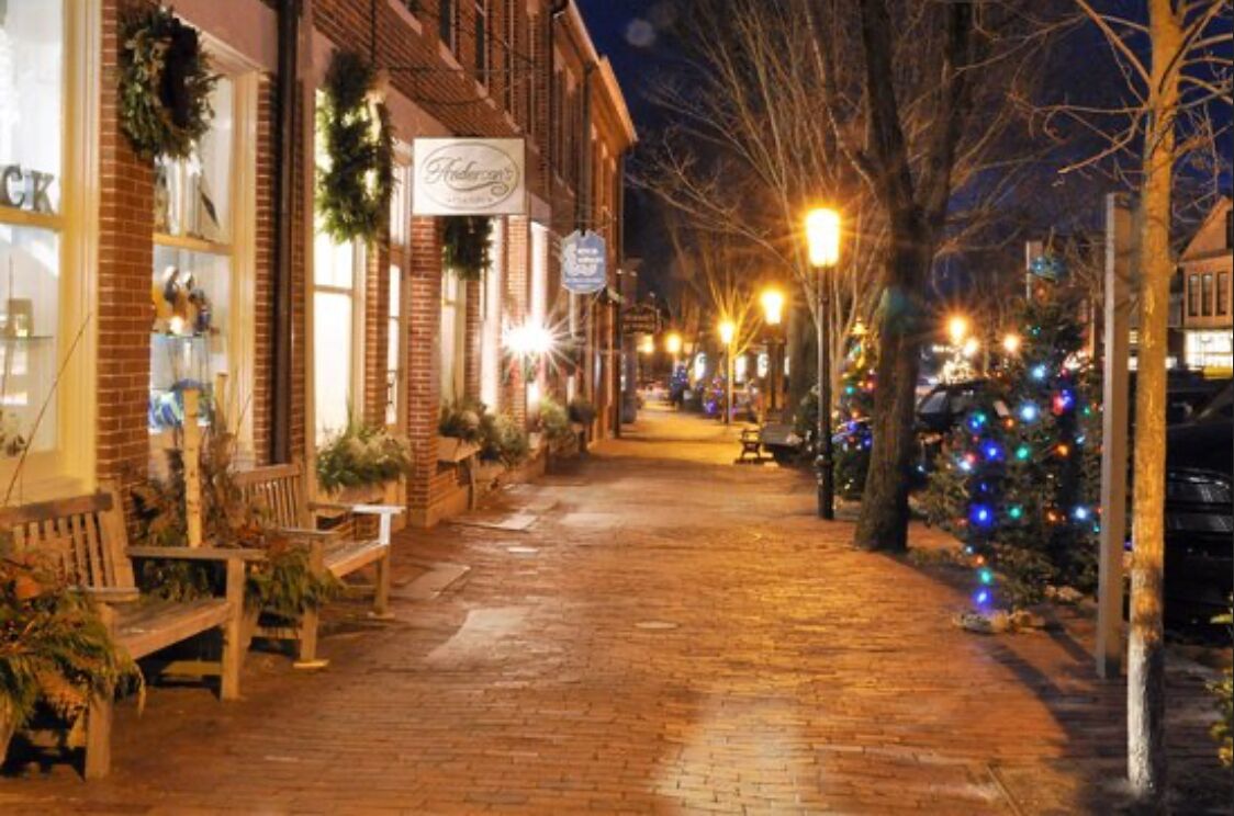 A brick-paved street with benches and Christmas decorations.