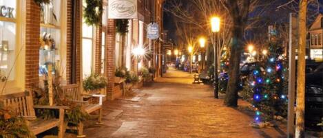 A brick-paved street with benches and Christmas decorations.