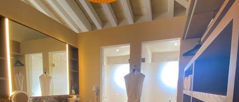 A modern bathroom with a large mirror, vanity, and a hanging light fixture.