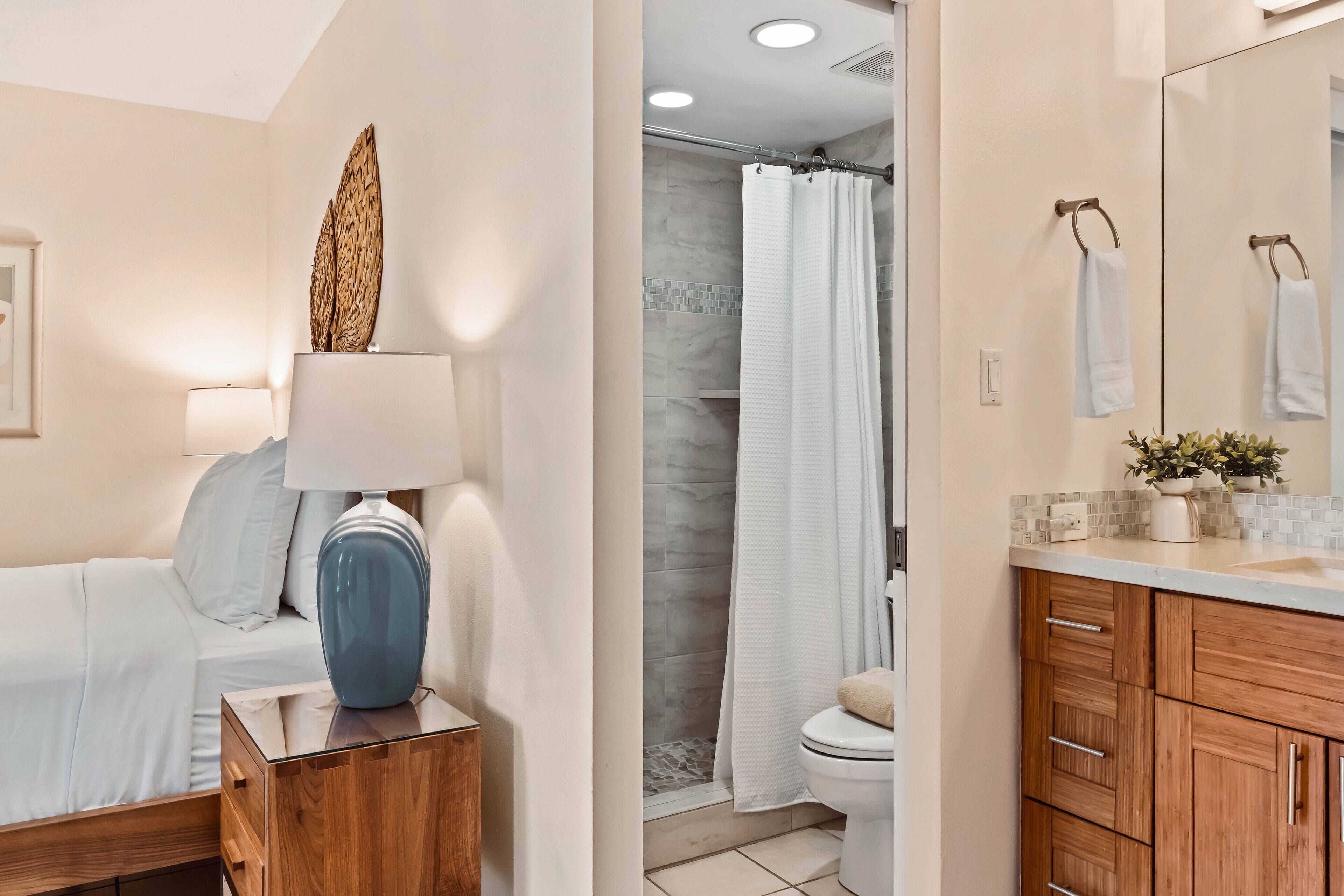 A modern bathroom with a shower, toilet, and vanity with a mirror.