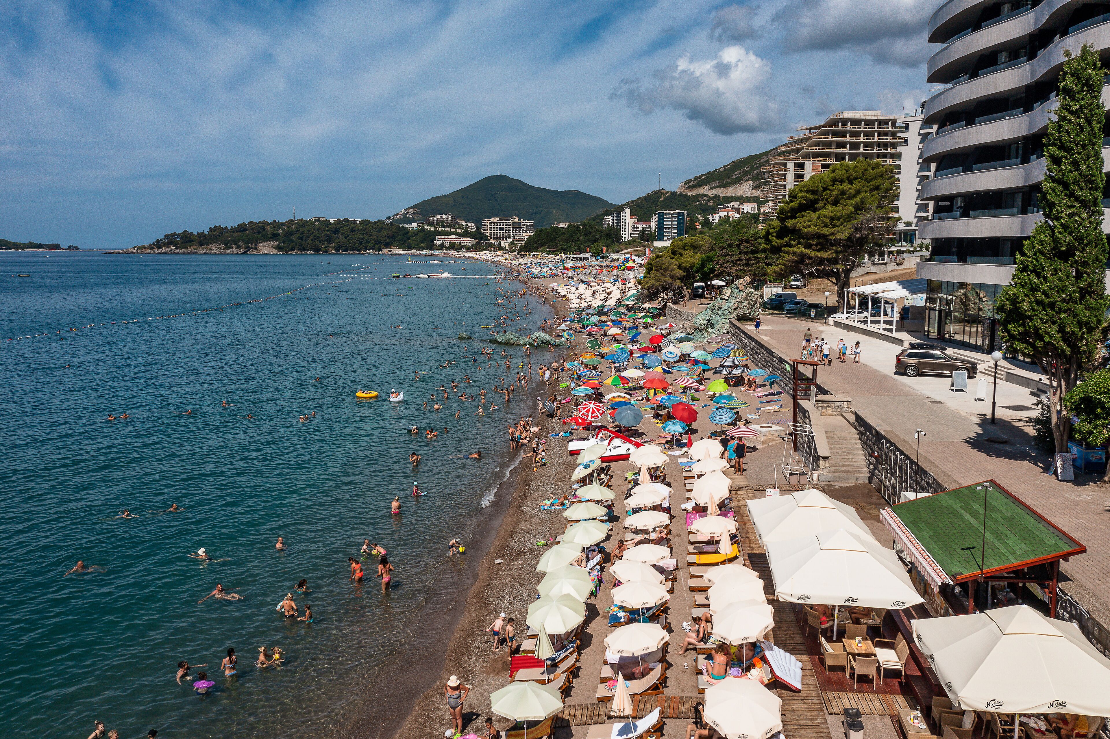 Une plage avec des parasols et des gens qui se baignent.