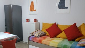 A compact room with a bed, a small table, and a refrigerator. - Feel at Home - CASA LA POSTA (Lovere)