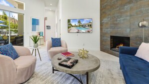 Una sala moderna con chimenea, una mesa redonda de centro y dos sofás.