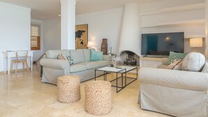 Un salon moderne avec un canapé, une table basse et deux poufs.