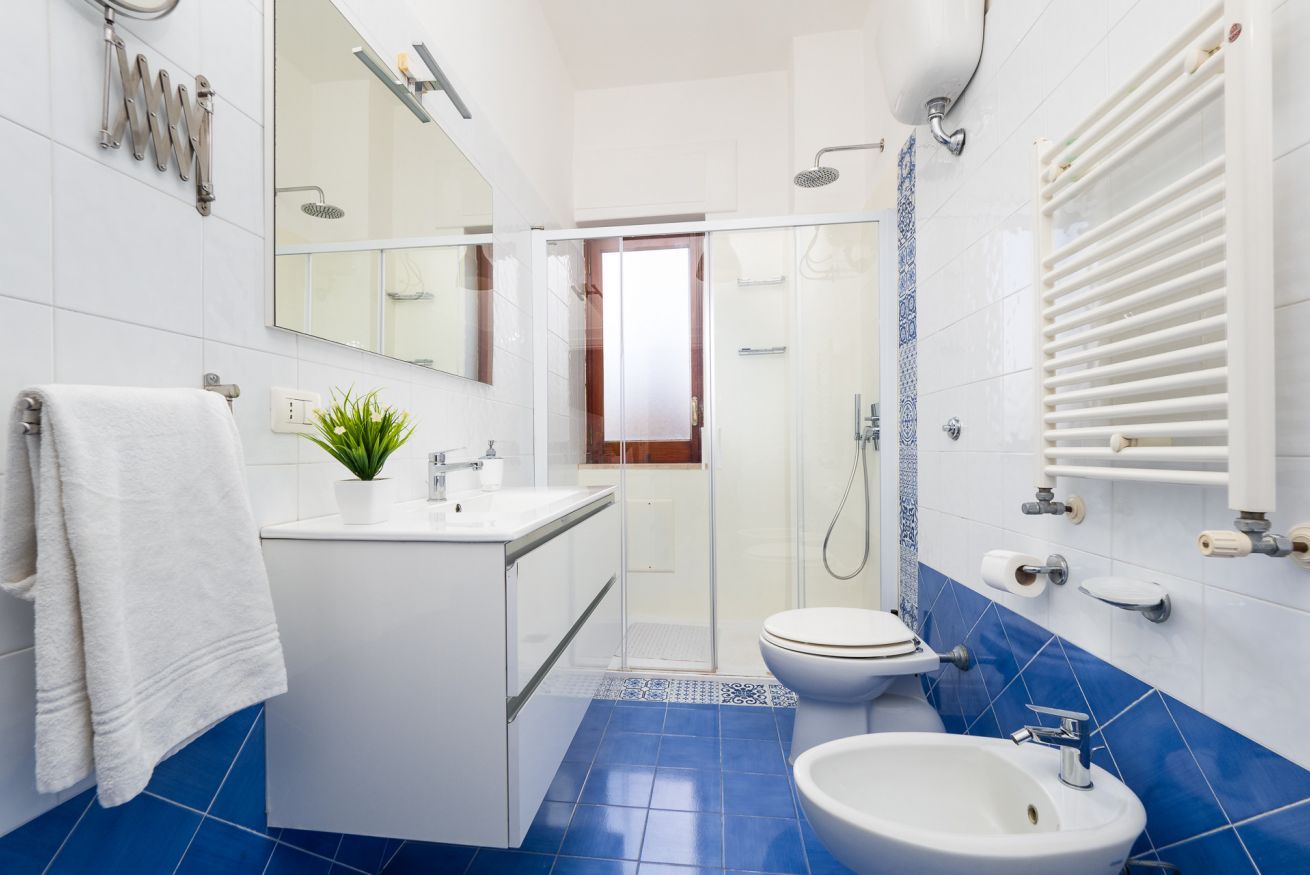 Ein modernes Badezimmer mit Dusche, Toilette, Waschbecken und einem großen Spiegel.