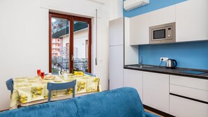 A compact kitchen with a microwave, kettle, and a dining area with a table set for two. - Smart Home Sorrento - City center (Sorrento)