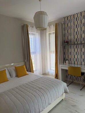 A hotel room with a bed, a desk, and a chair. - Beautiful 5 Rooms IN A Luxury Building (Netanya)