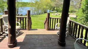 A wooden deck with a view of a lake and trees. - Cabin in the Vineyard. Very private! (Madison)