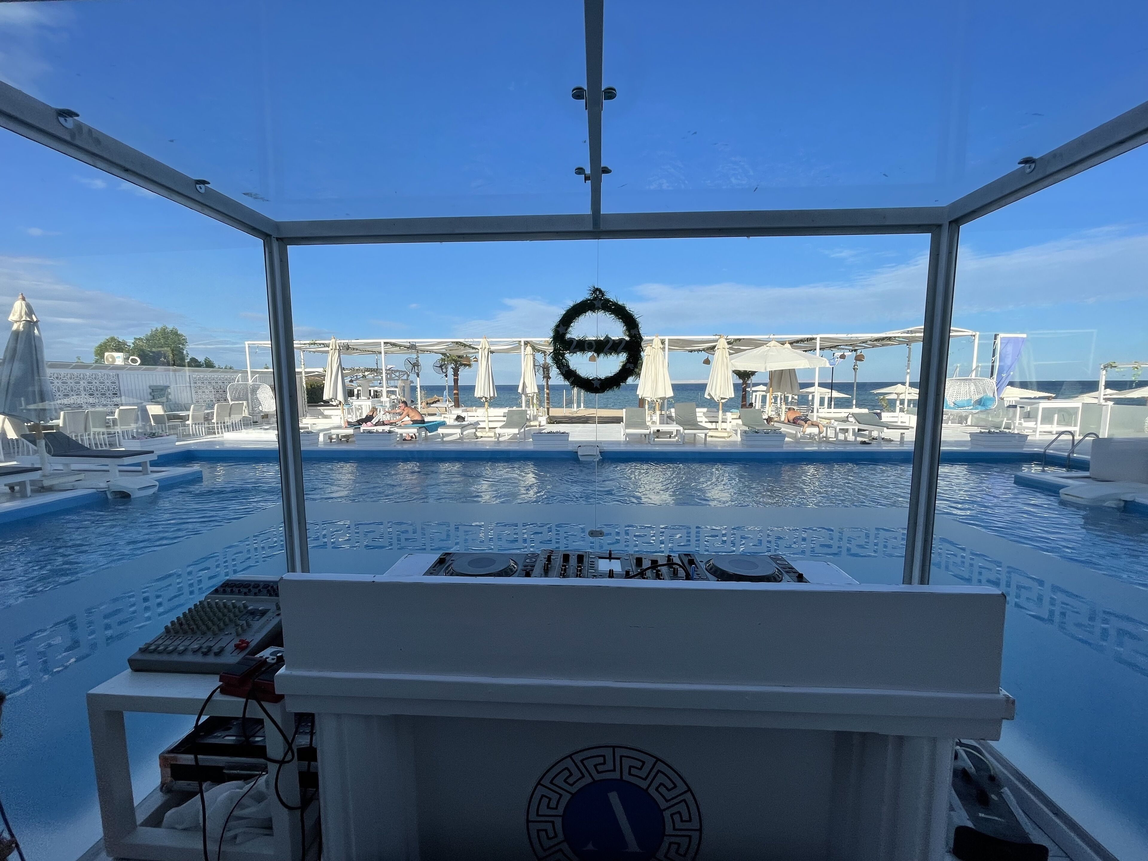 A view from a boat deck with a pool area, lounge chairs, and umbrellas.