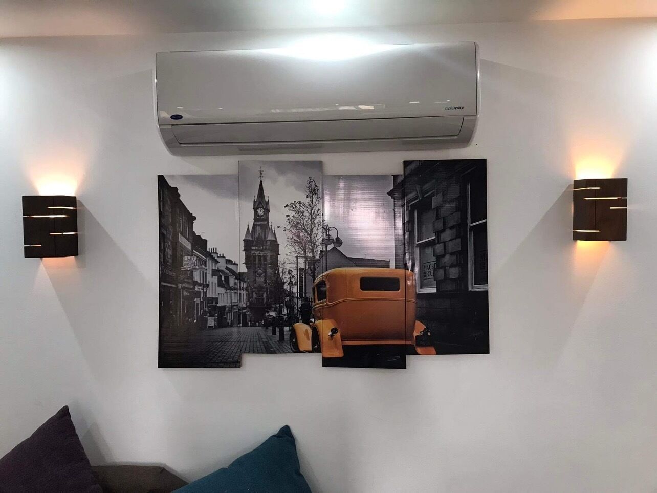 Ein Zimmer mit einer Wand-Klimaanlage, zwei Wandleuchten und einem großen Stadtbild.