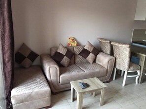 A living room with a sofa, armchair, and a small wooden table.