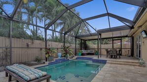 A covered outdoor swimming pool with a patio area, seating, and a view of the backyard. - Beautiful Home; Intimate Backyard with Private Pool Sleeps 8! (Wilton Manors)