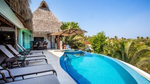 A poolside area with lounge chairs, a thatched-roof structure, and a view of palm trees. - Ocean views, breathtaking sunsets, gorgeous villa (Sayulita)