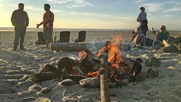 Guests can gather around the campfire on the wide, open beach.
