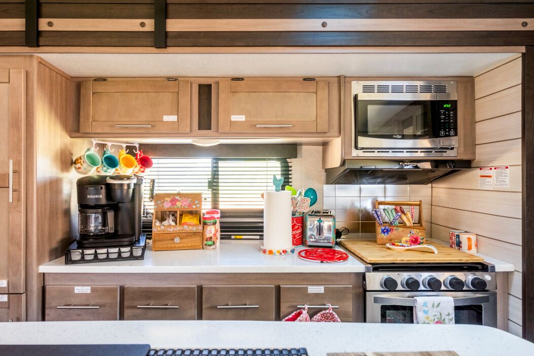 Cocina compacta para autocaravana con cafetera, microondas y estufa.