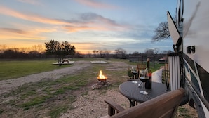 An outdoor patio with a fire pit, picnic table, and seating area.