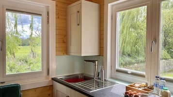 Kjøleskap, mikrobølgeovn, kjøkkenutstyr og spisebord