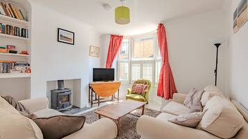 A living room with a fireplace, a television, and a bookshelf.
