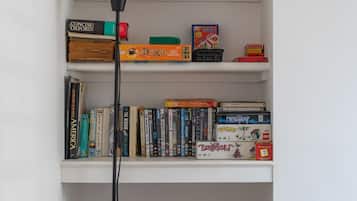 A bookshelf with various books, DVDs, and board games.
