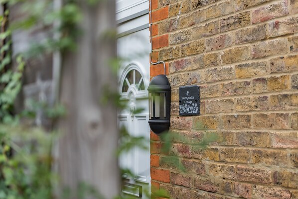 A brick wall with a door and a sign that reads "41 Honeysuckle Cottage." - Quaint fisherman’s cottage tucked away in a quite Deal street (Whitstable)