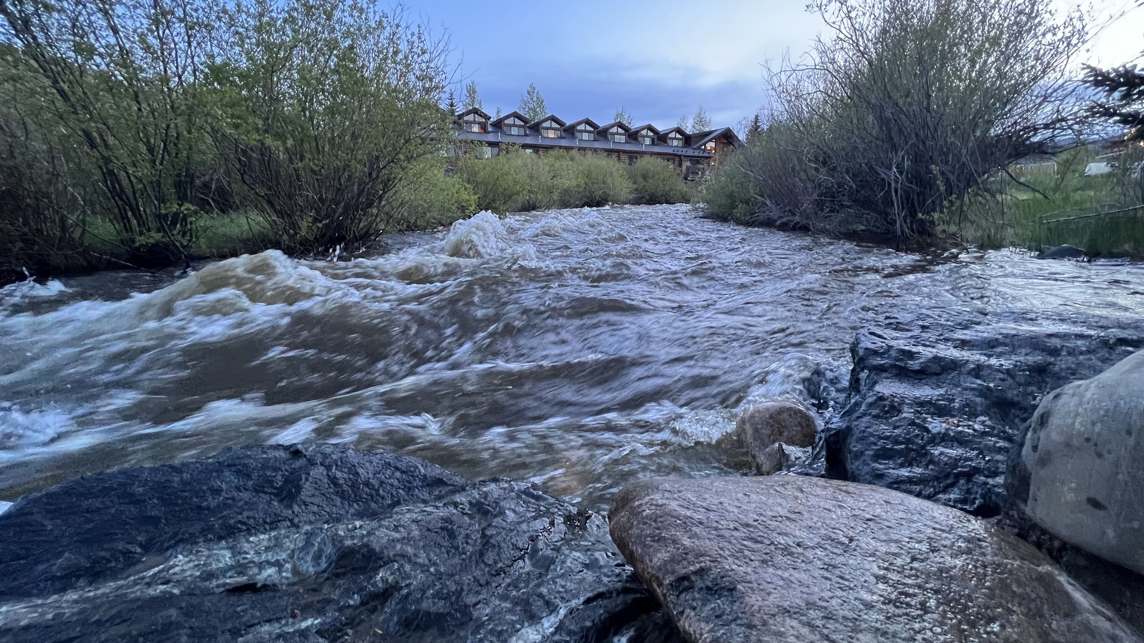 A river with a wooden structure in the background.