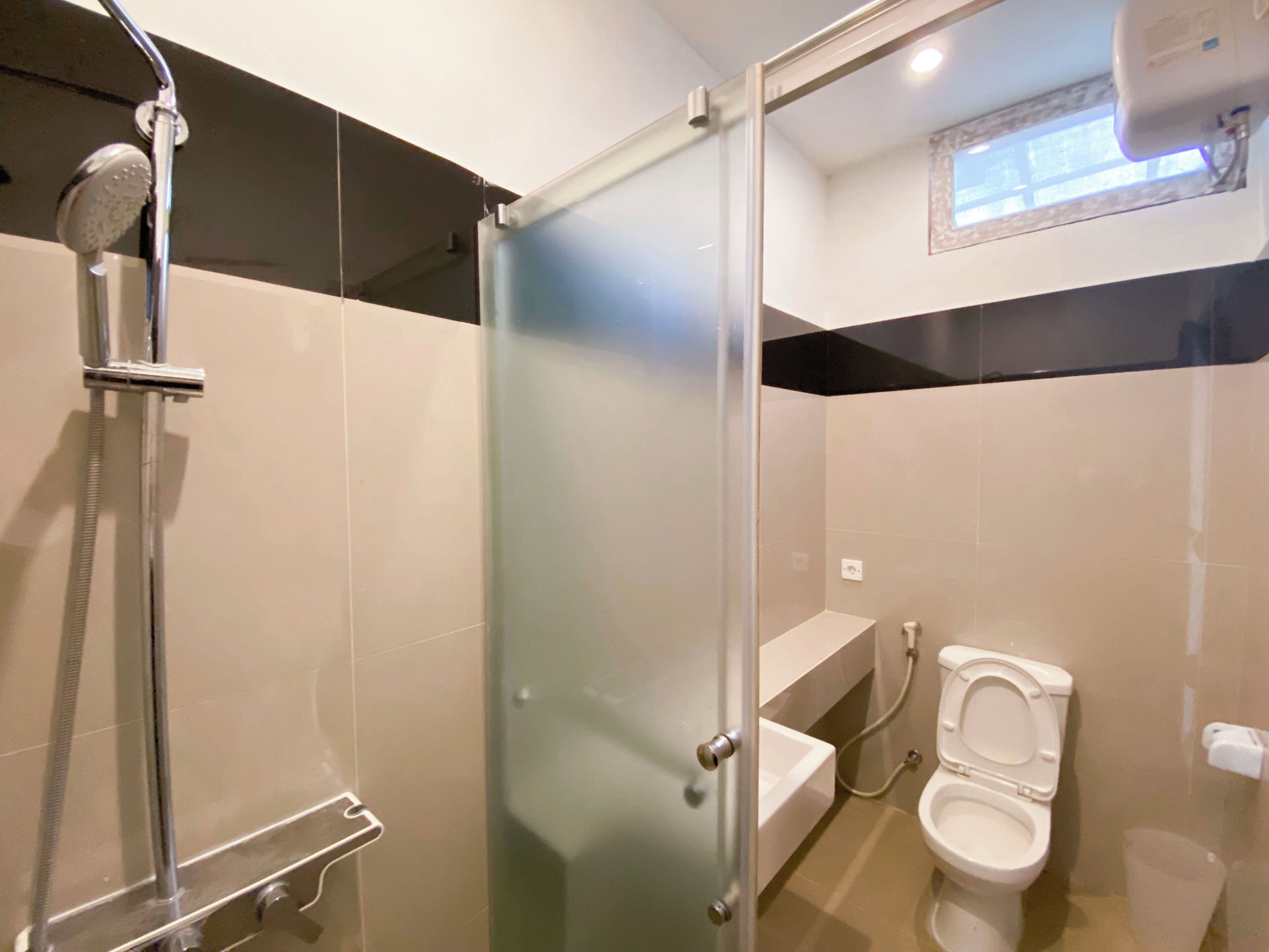 A modern bathroom with a glass shower enclosure, a toilet, and a sink.