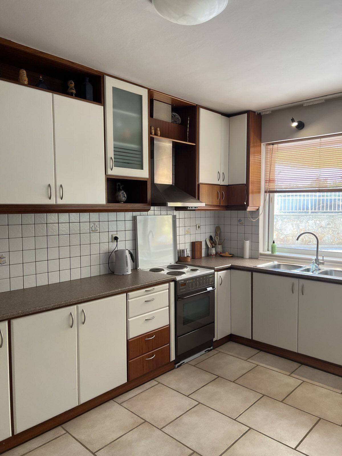 A kitchen with white cabinets, a stove, and a sink.