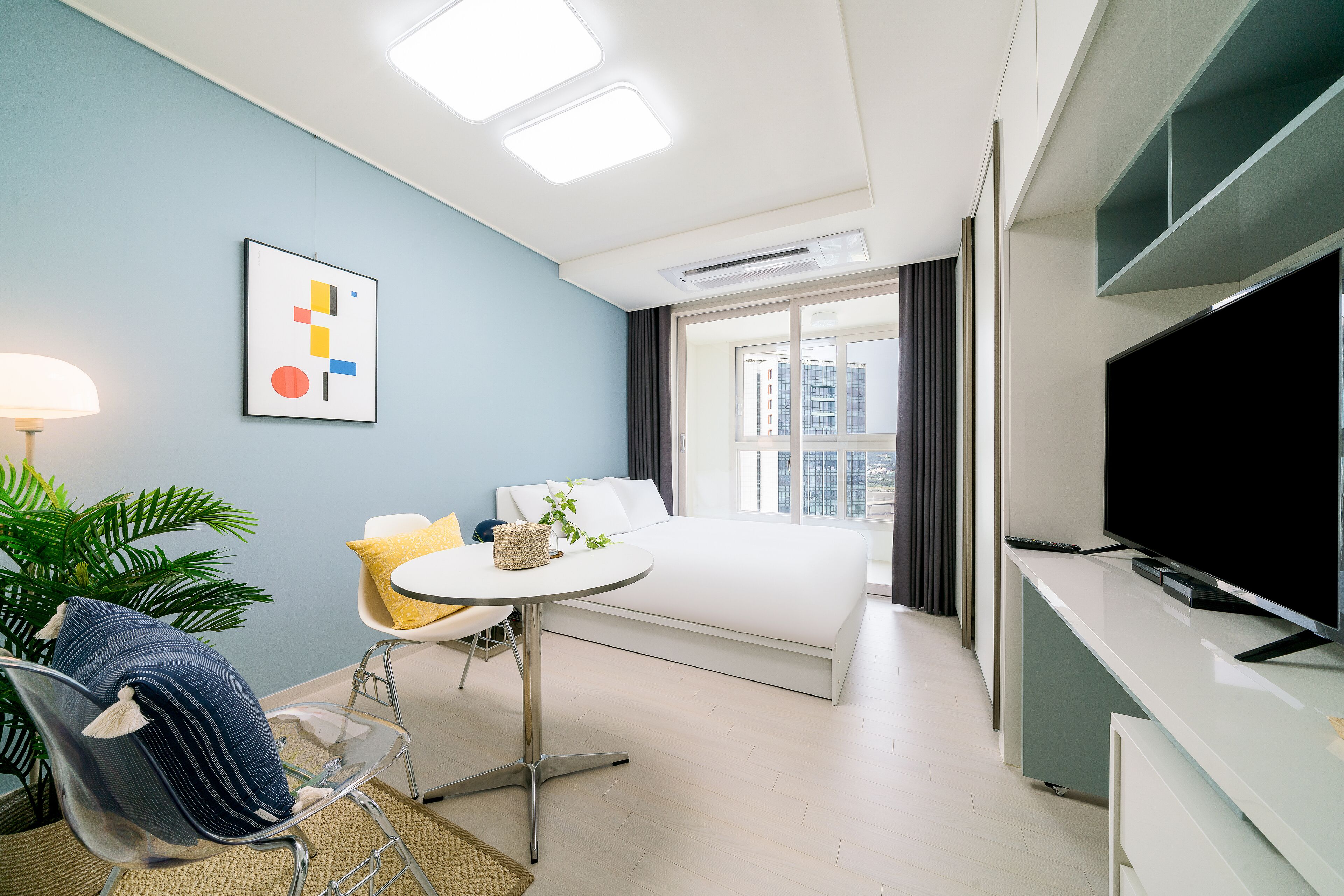 Une chambre d’hôtel moderne équipée d’un lit, d’une télévision, d’un bureau et d’une chaise.