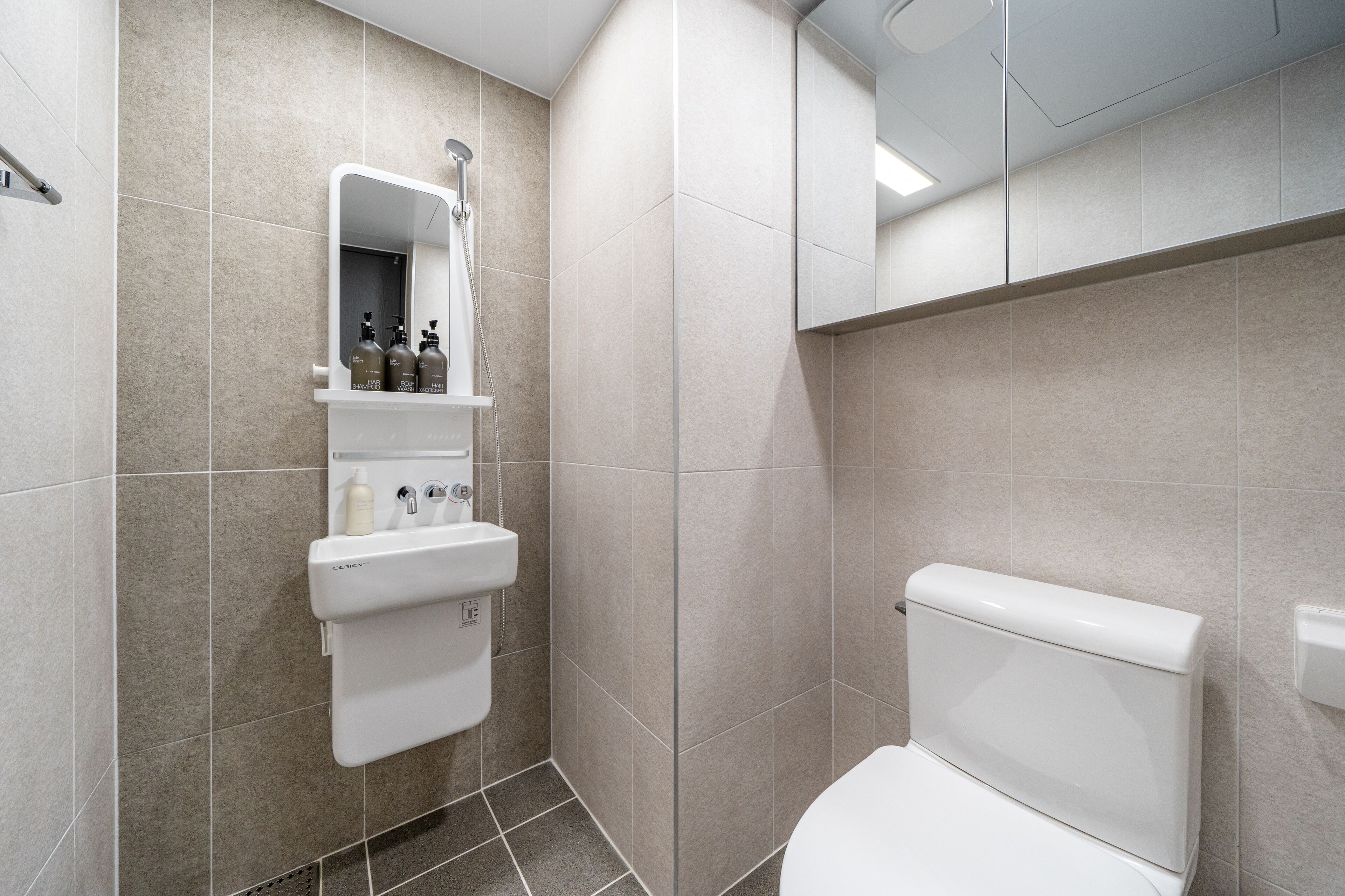 A modern bathroom with a toilet, a sink, and a mirror.