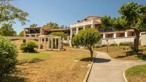 Un immeuble résidentiel moderne doté de nombreux balcons, d’une cour intérieure et entouré de verdure.