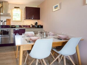 Une cuisine moderne avec un coin repas aménagé pour deux personnes.