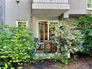 A residential building with a balcony, a wooden deck, and a garden area with various plants. - JUPAS° Red Rock Home – 2 Balconies & Carport (Trier)