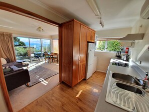 Enjoy a compact kitchen with appliances, dining area, and cozy seating area with views of the surrounding landscape.
