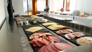 A buffet with various cheeses, meats, and a microwave in the background. - Hotel Schneiderhof (Braunlage)