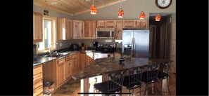 Enjoy cooking in this well-equipped kitchen with a central island, stainless steel appliances, and ample natural light.