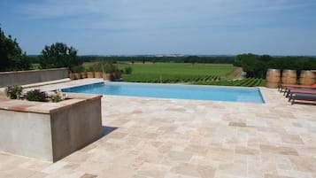 Una piscina al aire libre de temporada, sombrillas, tumbonas