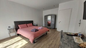 A bedroom with a bed, bedside tables, a wardrobe, a desk, and a chair. - Domaine de Codeval (Fronton)